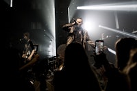 a man on stage with a microphone in front of a crowd