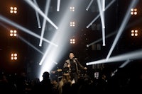 a man on stage with lights shining on him