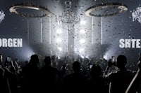 a group of people standing in front of a chandelier