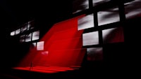 a person standing in front of a red light in a dark room