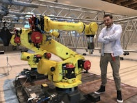 a man standing on top of a yellow robot